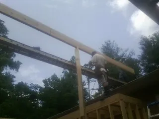 Carpenter setting a ridge beam over a new addition frame — Ice Dam Removal by Roofing Brothers in Rumford