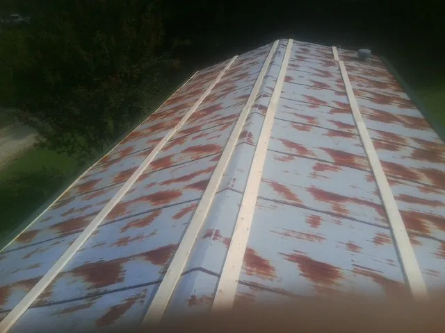 Rusted metal roof panels with new wood purlins before replacement — Storm Damage Roof Repair in Rumford by Roofing Brothers