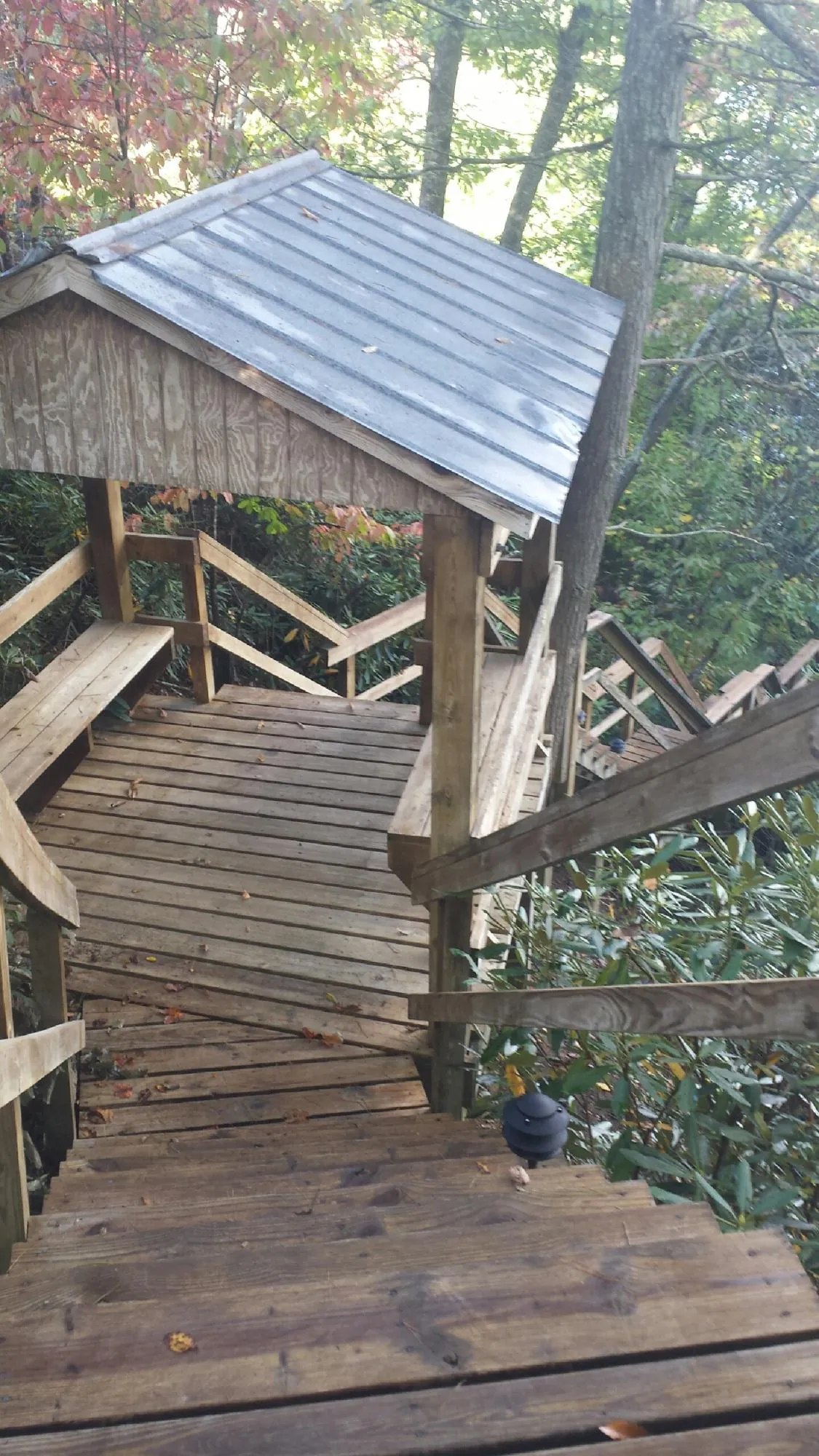 Metal roofed shelter over wooden steps on a wooded walkway — Skylight Repair & Installation work by our crew in Rumford